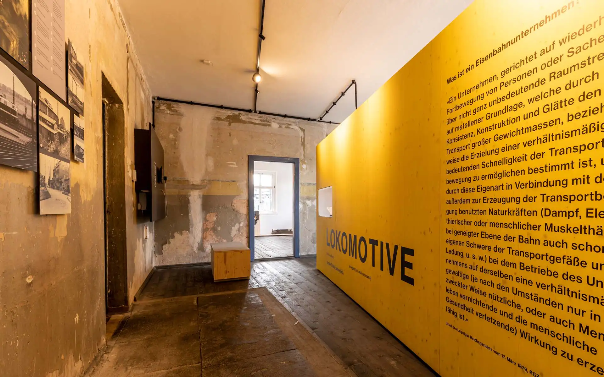 Ausstellungsraum mit gelber Wand 'Lokomotive' und historischen Fotos