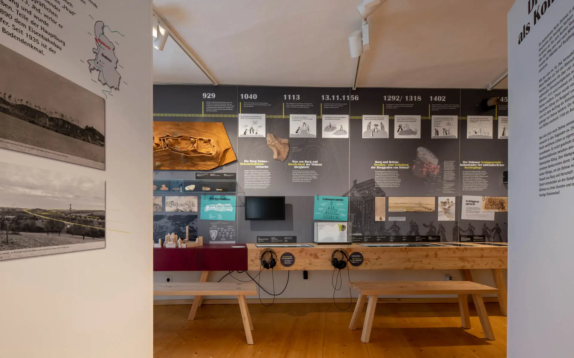 Zeitstrahl-Wand mit historischen Daten und Illustrationen. Sitzbänke und Medienstationen im Ausstellungsraum.