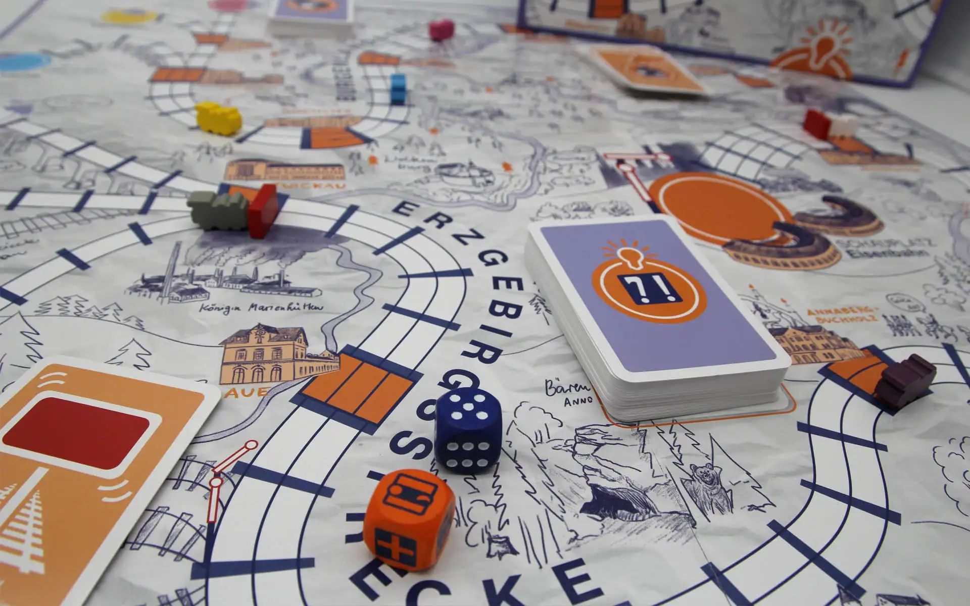 Detail des Spielplans mit Kartenstapel, Würfeln und Spielfiguren