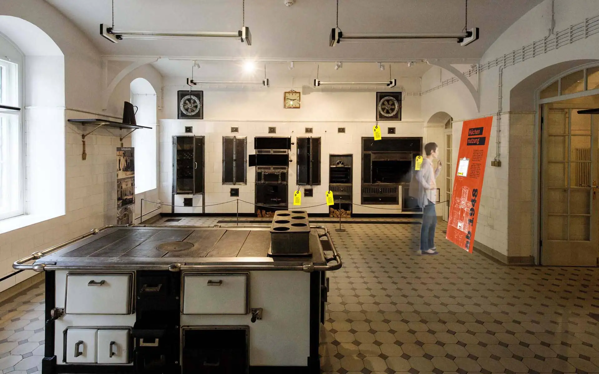 Historische Schlossküche mit großem Herd, Öfen und roter Informationstafel