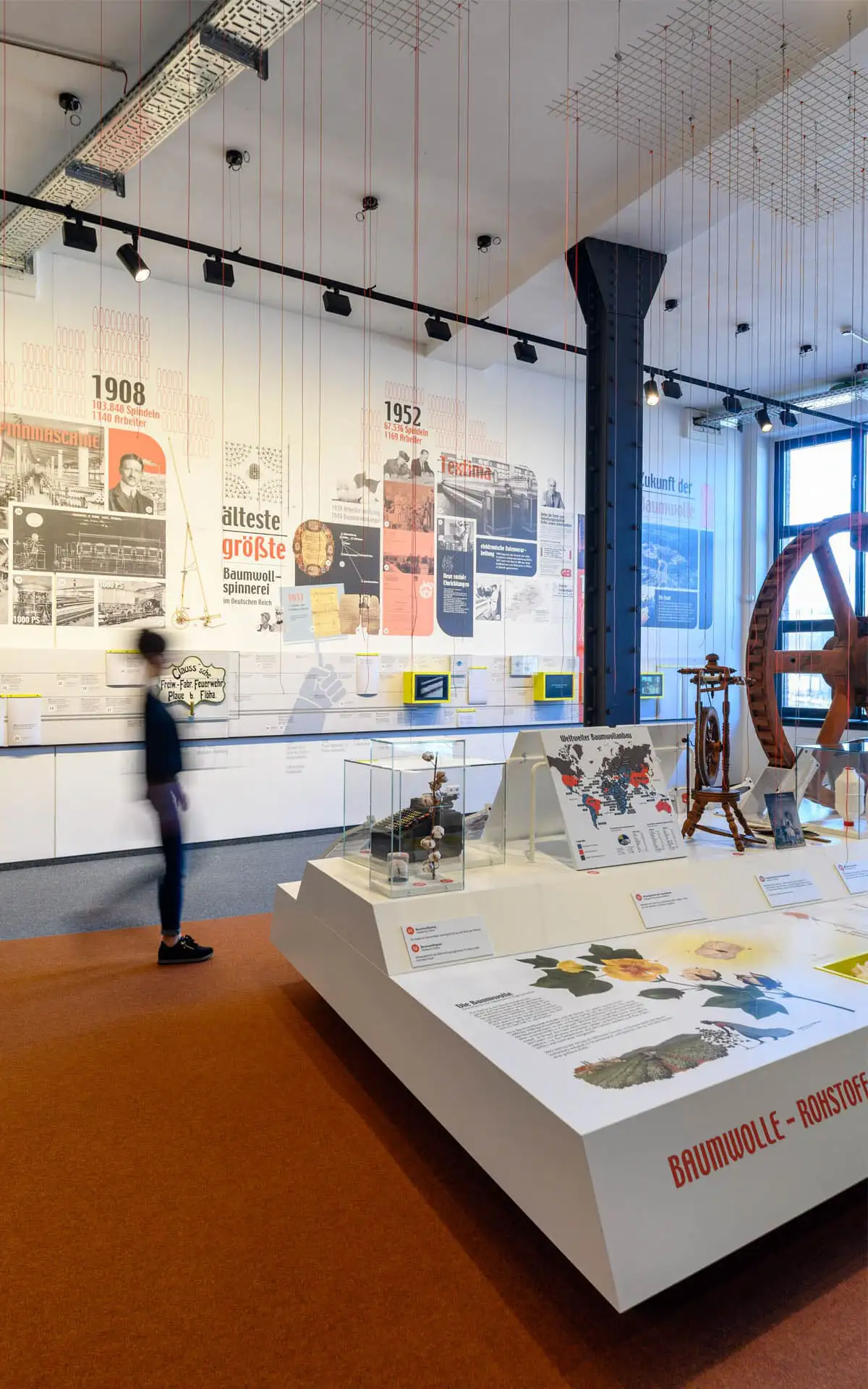 Detail des Ausstellungsraums mit Zeitwand, Vitrine und großem Antriebsrad