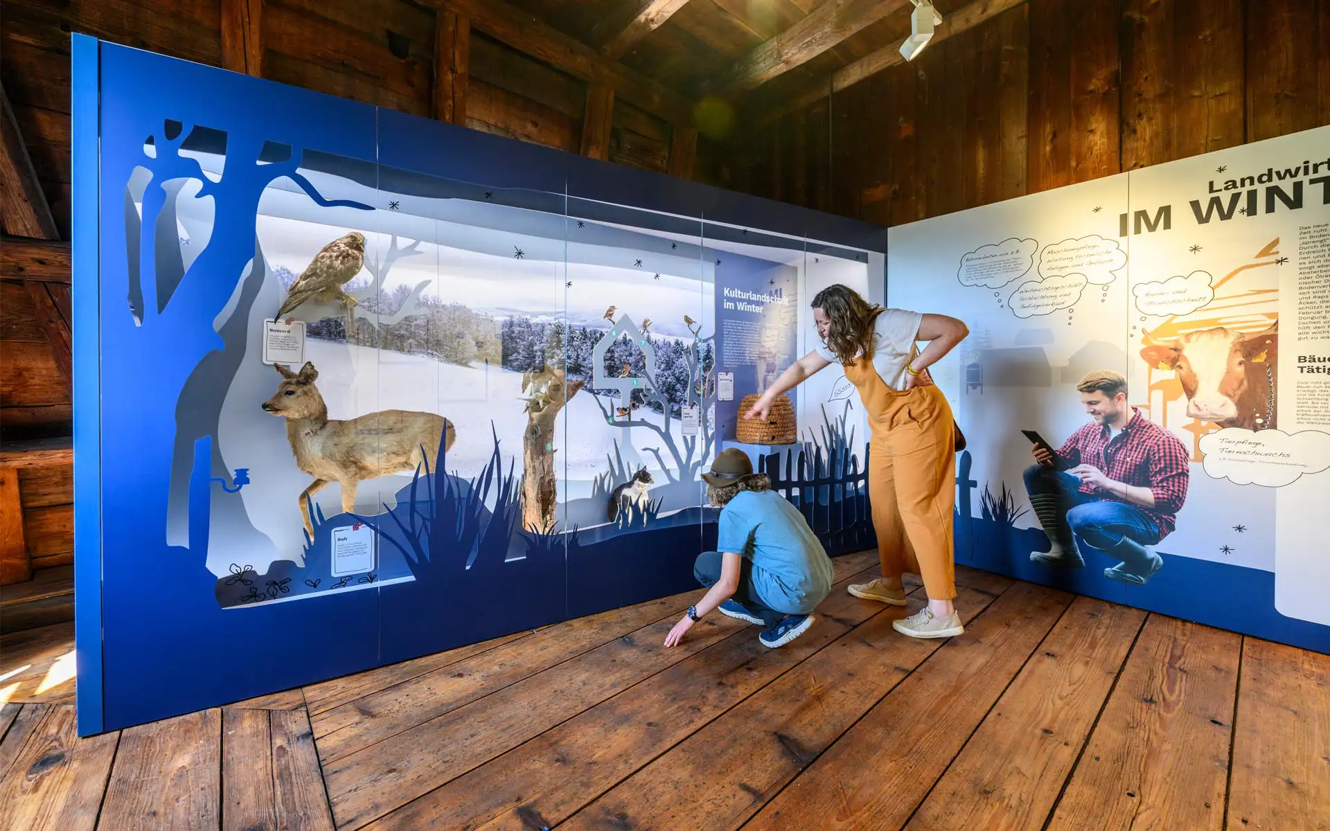 Diorama mit Präparaten von Reh und Greifvogel in blauer Silhouettenlandschaft