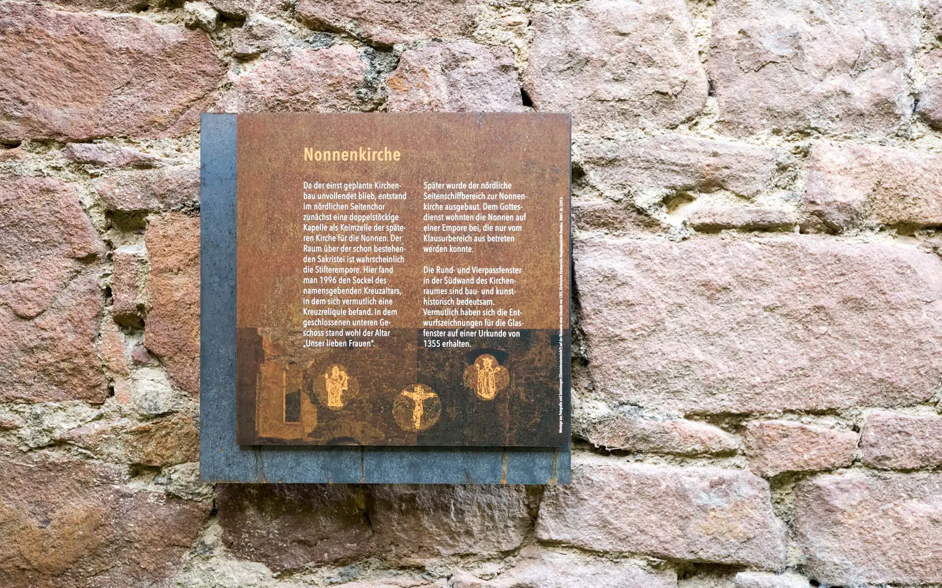 Nahaufnahme der Informationstafel Nonnenkirche auf grobem Mauerwerk