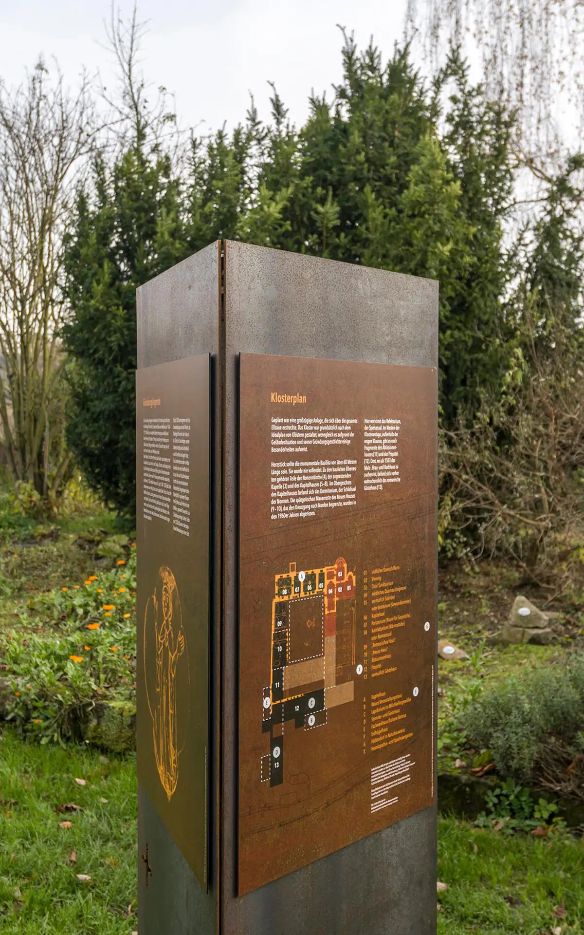 Informationstafel Klosterplan mit Grundrissdarstellung und Beschriftungen auf einer Stahlsäule im Außenbereich