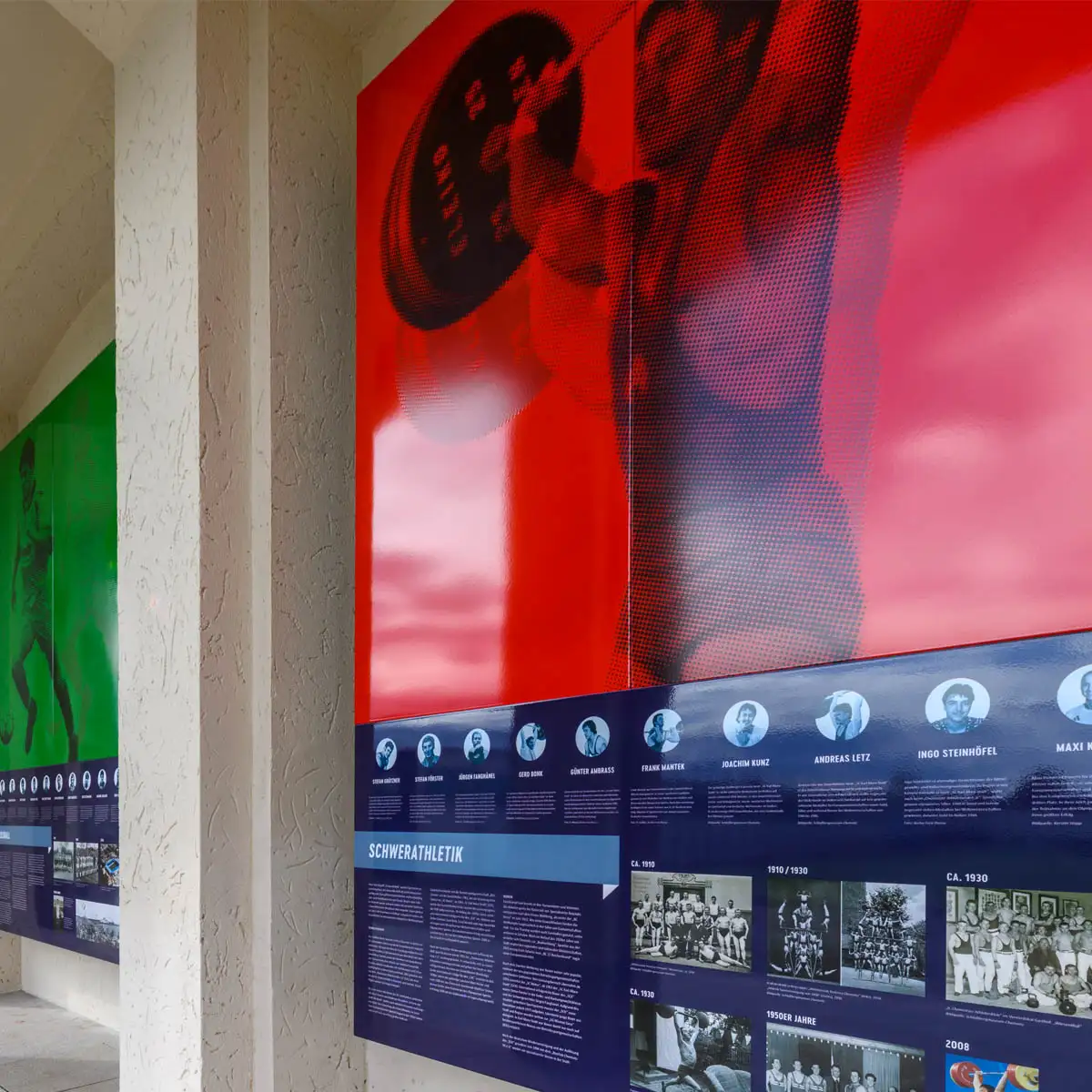 Detail der roten Schwerathletik-Tafel: Gewichtheber vor Bildleiste mit historischen Motiven