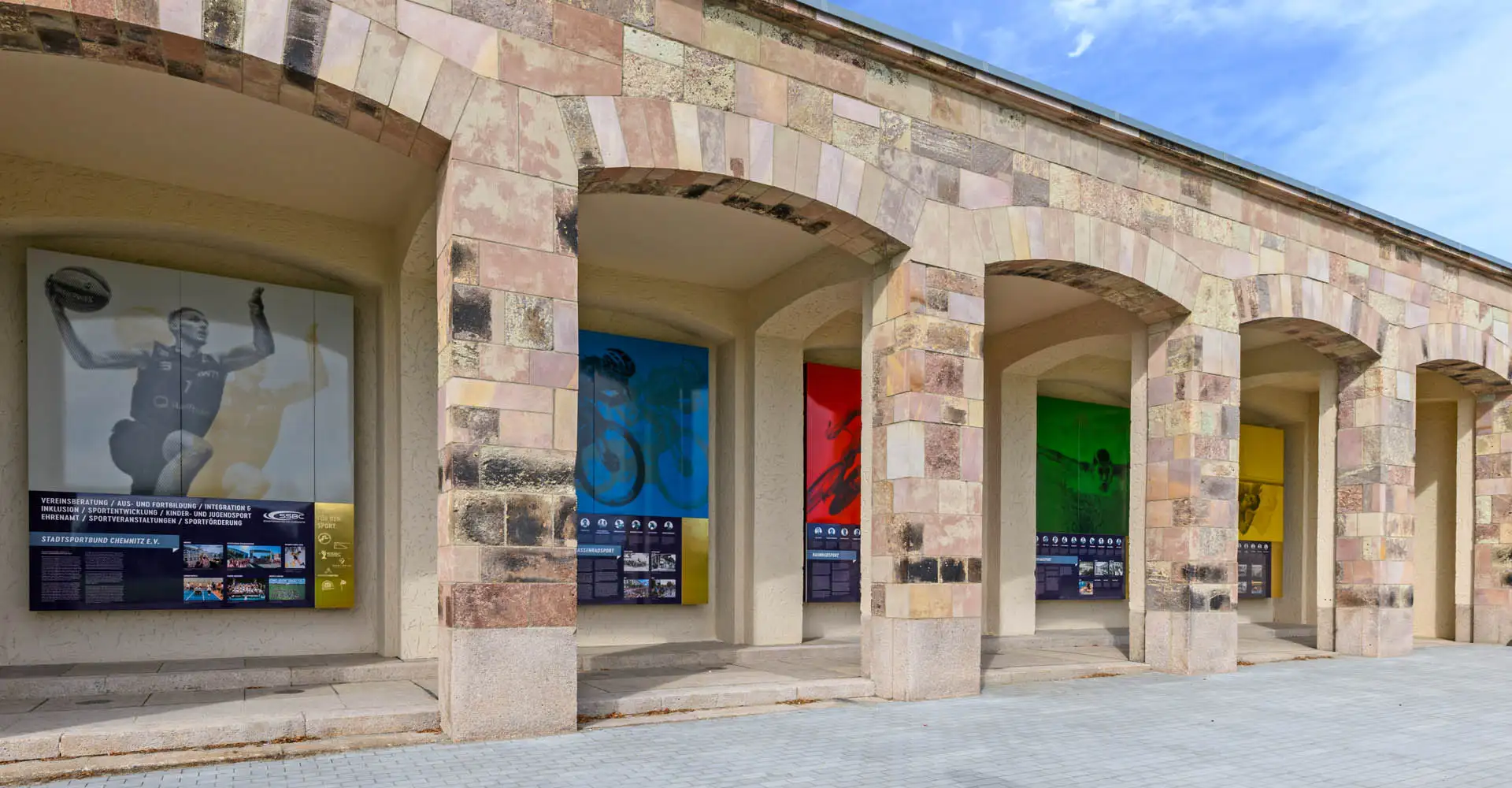 Reihe der Sporttafeln in den Arkaden – Basketball, Radsport, Kraftsport, Schwimmen und Turnen