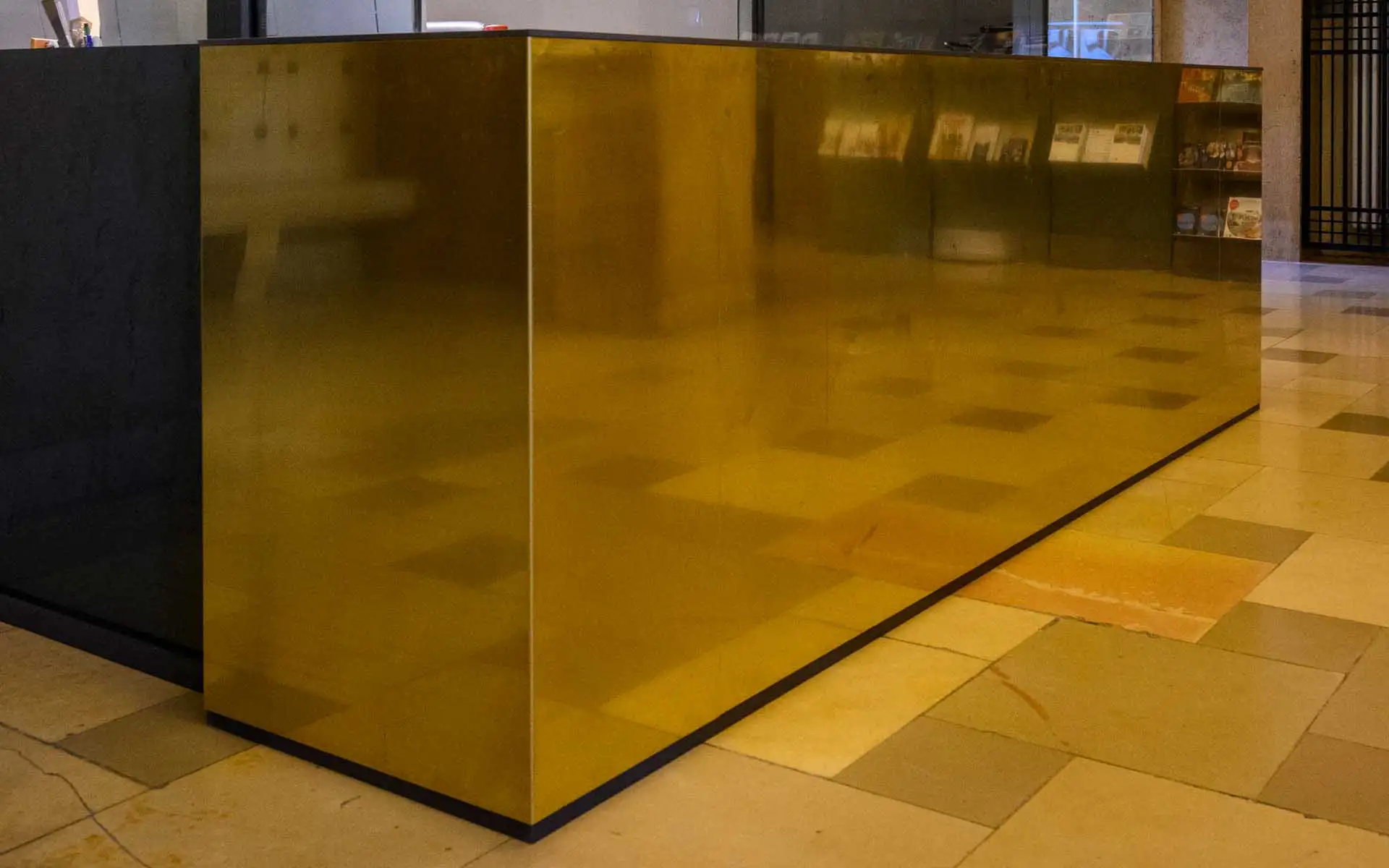 Detailansicht einer Messingfläche mit Spiegelungen des historischen Innenraums