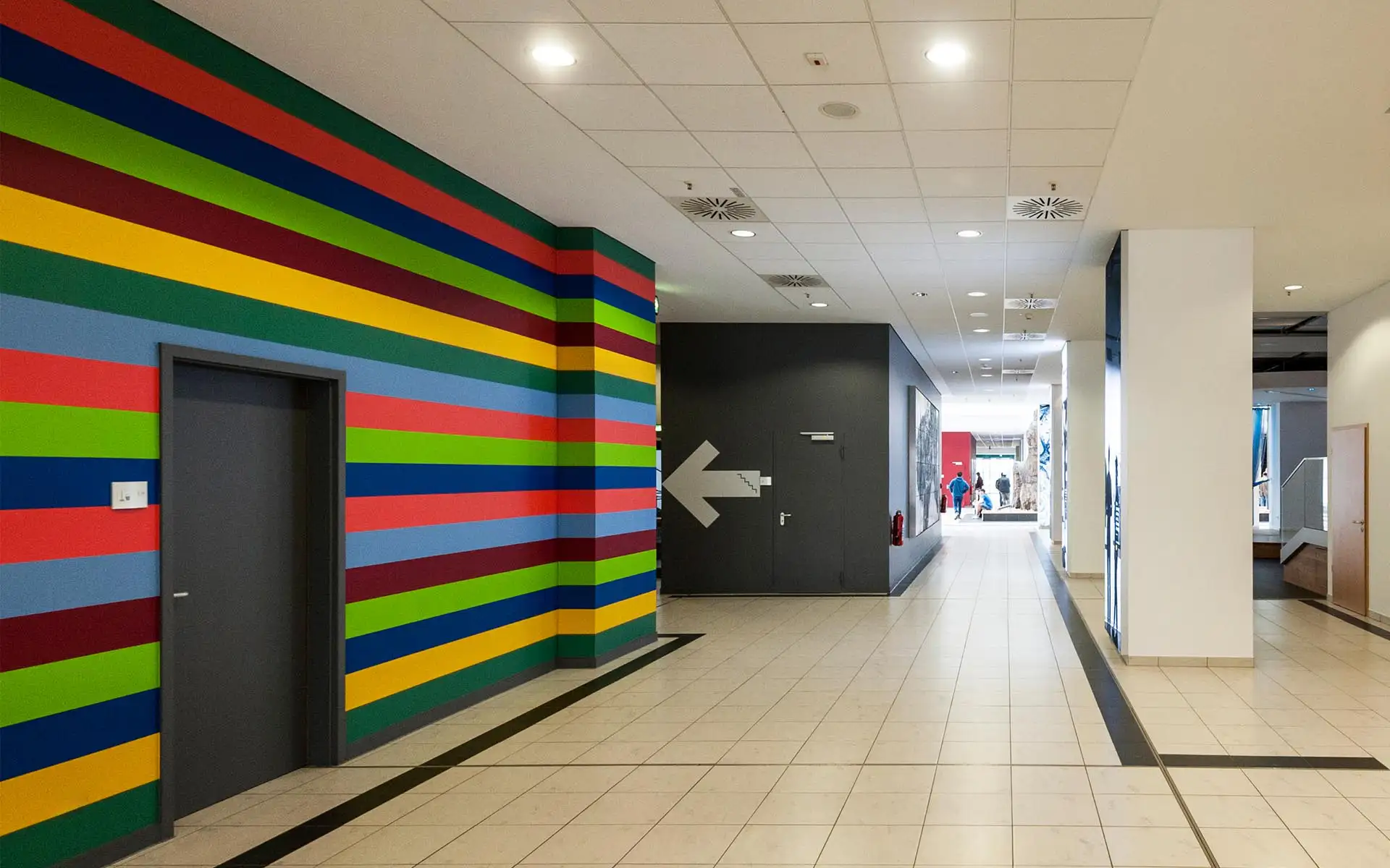 Innenraum im Tietz mit farbigen horizontalen Wandstreifen als Teil des Leitsystems.
