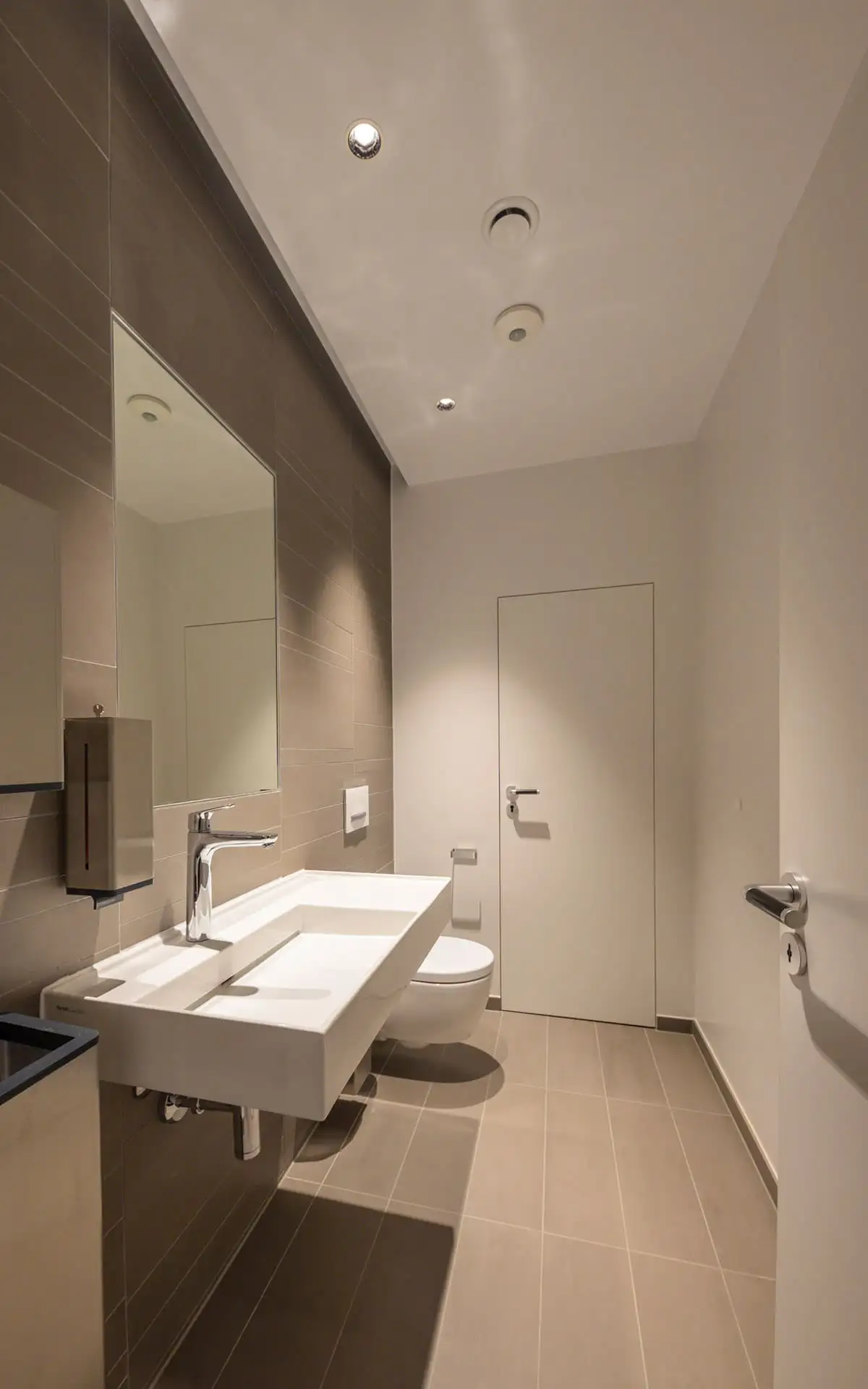 Sanitärraum mit Waschtisch, Spiegel und wandhängendem WC