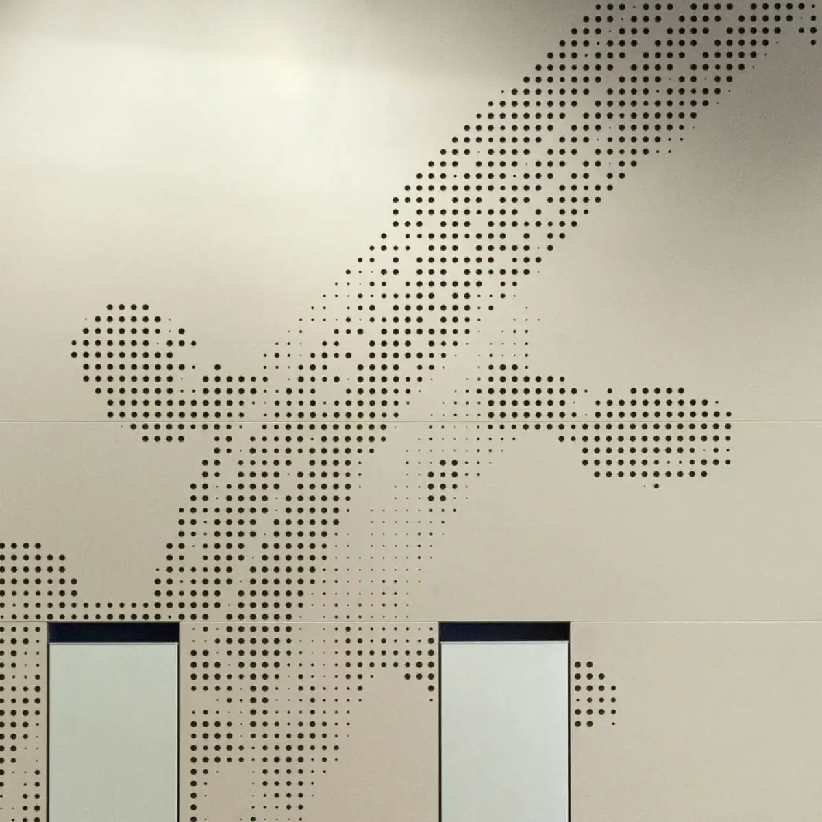 Detail der gelochten Akustikplatten im Foyer: grafisches Punktraster an der Wand.