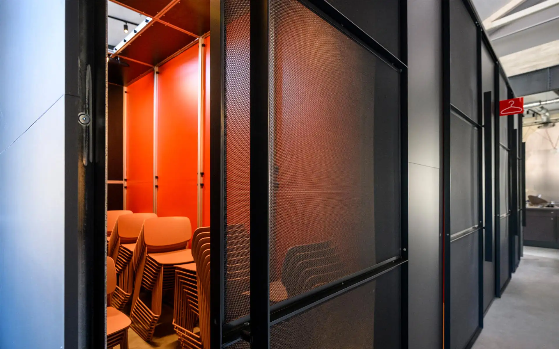 Stuhl-Depot hinter transluzenten Paneelen, orangefarbener Innenraum