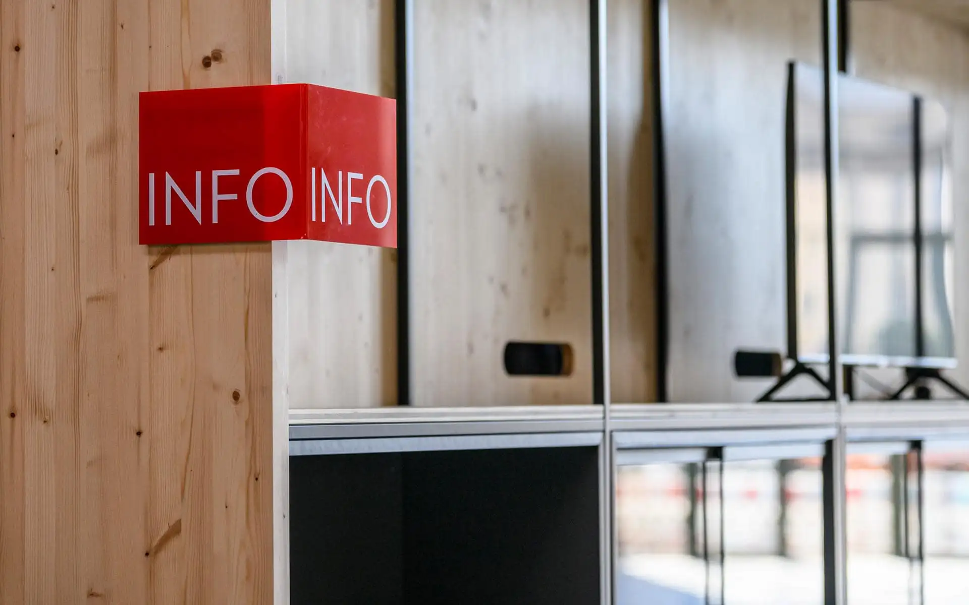 Rotes Info-Schild an Holzelement, Detail